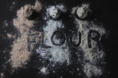 Üç kavanoz dolusu un, glütensiz alternatifler, serpiştirilmiş un ve en üstte 