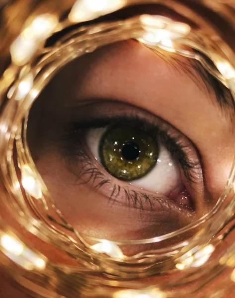 Space stars in your eyes. Girl with green eyes. Lights reflection. Bright sight. Yellow flashlights