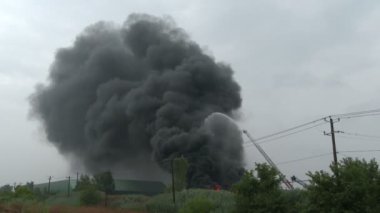 Büyük siyah duman sütunu ticari yangında yükseliyor