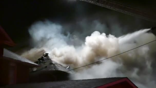 煙と家の火災で屋根の上に水を置く空中はしご — ストック動画