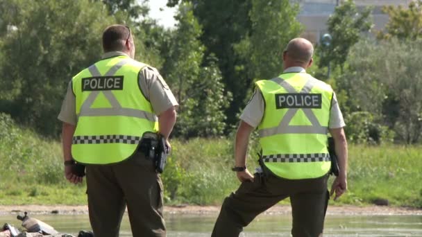 Två Poliser Som Pratar Vid Sidan Flod — Stockvideo