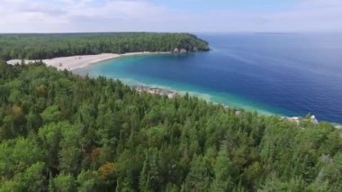 Kanada çam ormanlarındaki mavi su koyunun ve plajın güzel hava manzarası
