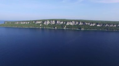 İHA uçuyor ve yüksek kayalıklarla geniş kıyı şeridini açığa çıkarıyor.