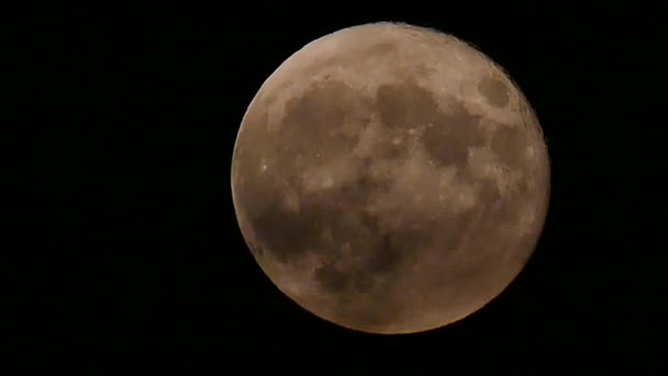 Super gros plan de la lune se levant en temps réel avec des nuages légers 