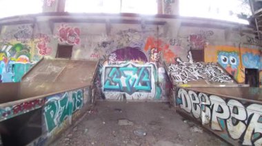 Urbex sırasında glidekste grafiti görüntüsüyle kaplı büyük metal kaplar.