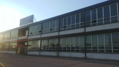 Kapatılan cam pencereli iki katlı binanın ön cephesi.