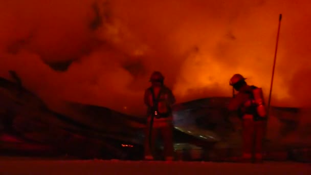 Feuerwehrmann Setzt Wasser Brand Das Helle Glühende Rauchschwaden Erzeugt — Stockvideo