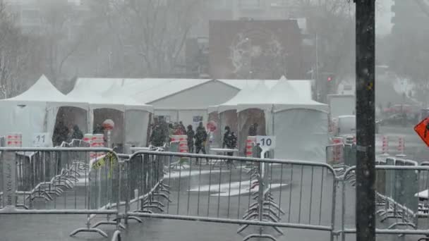 市内の屋外の歩行クリニックをスクリーニングコロナウイルスのシーンで降雪 — ストック動画