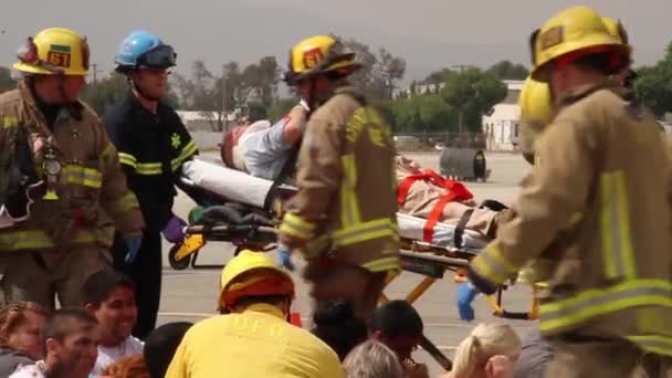 消防员及医护人员将病人抬到担架内 — 图库视频影像