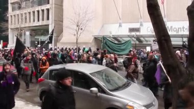 Bayraklı protestocular şehir merkezinde yürüyor.