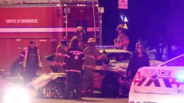 İtfaiye ekipleri, gece geçirdikleri bir kazadan sonra arabalarında mahsur kalan iki polis memurunu kurtarmak için can dişlerini kullanıyor..