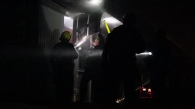 Geceleri el fenerleriyle çalışan itfaiyeciler.