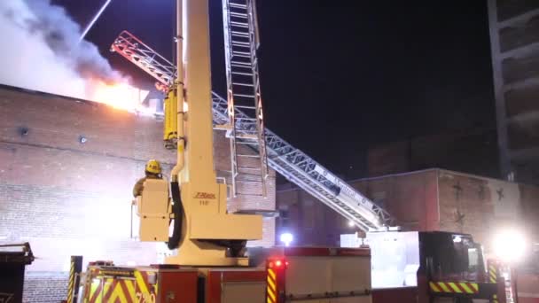 消防士が建物の上で火事を見て — ストック動画