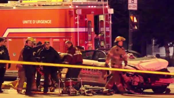 紧急救援人员将一名女警官从一辆警车撞车中抬进担架 然后进入一辆救护车 — 图库视频影像
