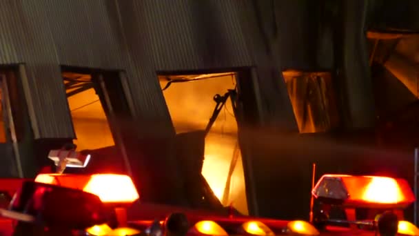 水と消防車の赤いライトのジェットで大規模な工場火災 — ストック動画