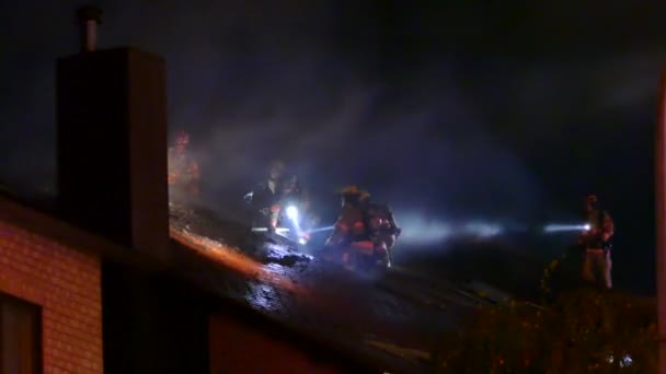Feuerwehrmann Schlägt Dach Ein Während Darauf Steht — Stockvideo