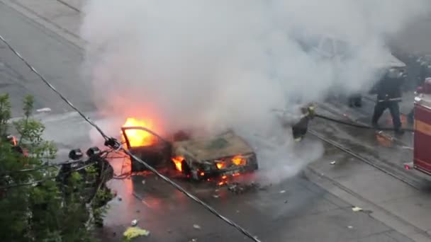 警官と消防士が煙で車の火の周りを歩く — ストック動画