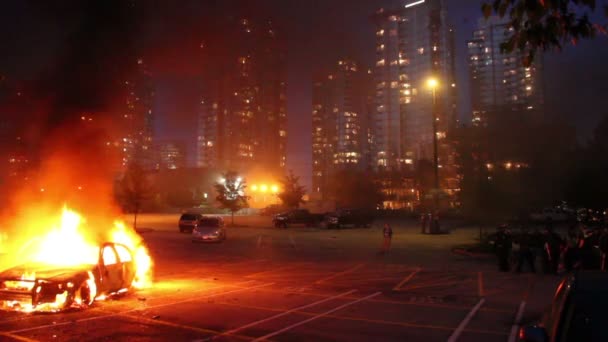高層ビルの炎に巻き込まれた車とSwatの将校が立っている — ストック動画