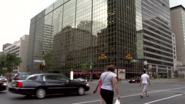 Arabalar ve yayalar arka plandaki bina gibi aynalarla kesişiyor.