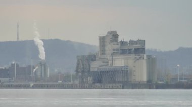 Alacakaranlıkta sanayi bölgesinden geçen arabalar