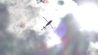 Helikopter, güneş ışınları ve alevlerle aşağıdan görünüyor.