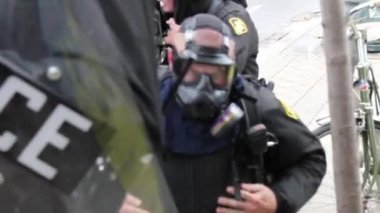 Çevik kuvvet polisleri çiçekli gaz maskeleri takıyor.