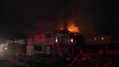 Geceleri evin geniş karanlık manzarası, çatıda ateş görünüyor.