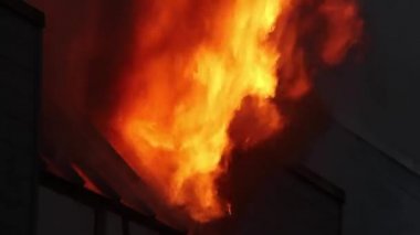 Şiddetli parlak alev gece yangın sırasında açılı pencereden dışarı fırlıyor