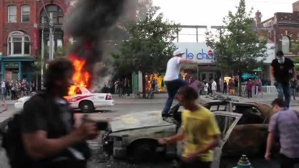 Randalierer Springen Und Setzen Polizeiautos Brand — Stockvideo