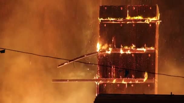 火の上の木の大きな板は途中で落下し 構造の残りの部分に固執したまま — ストック動画