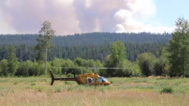 手前に黄色のヘリコプターで山火事から煙の噴煙の大雲 — ストック動画