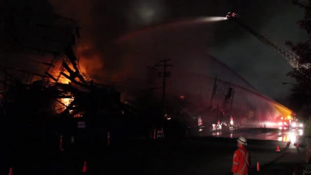 Δημοτικός Υπάλληλος Πορτοκαλί Γιλέκο Κοιτάζοντας Επακόλουθα Της Μεγάλης Πυρκαγιάς Νύχτα — Αρχείο Βίντεο