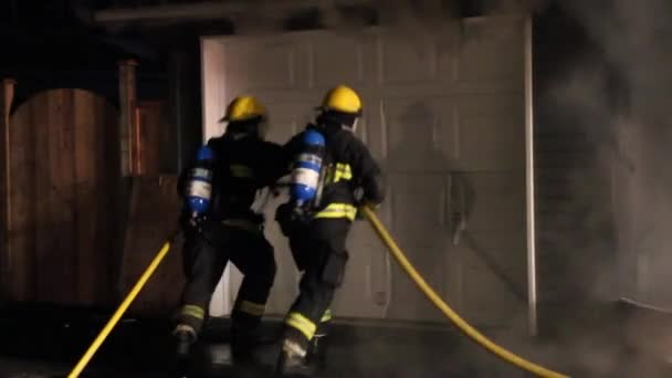 Brandmænd Sparke Garage Dør Samtidigt Ironisk Visning Brandslukning – Stock-video
