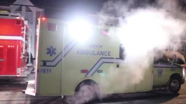 Sarı ambulans karlı bir yolda geri geri gidiyor.