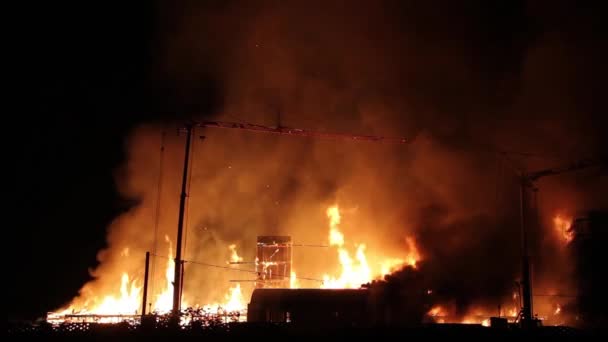 夜の火災をリッピングすると 建物のサイトで遠くに沿って広がる炎を示しています — ストック動画