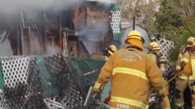 İtfaiyeciler ateşe balta ve testere ile karşılık veriyor.