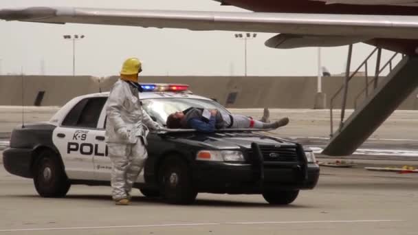 Πυροσβέστης Αεροδρομίου Μεταφέρει Θύμα Στο Αυτοκίνητο Της Αστυνομίας — Αρχείο Βίντεο