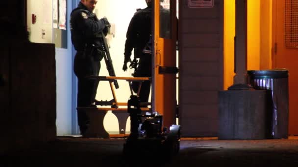 携带霰弹枪的特警队人员盯着亮着灯的遥控警察机器人 — 图库视频影像