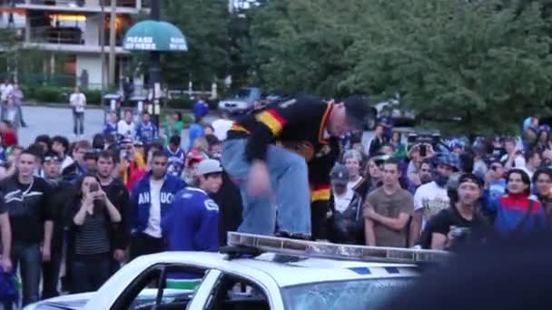 Mann Mit Eishockeytrikot Schlägt Polizeiauto Bei Randale Aufs Dach — Stockvideo