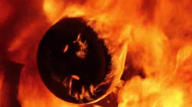 Kargaşada devrilmiş bir aracın alevlerinde yanan kauçuğa yakın çekim