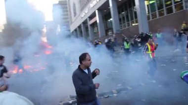 Patlayıcı göz yaşartıcı gaz ve etrafta koşuşturan insanların olduğu kaotik gerilim sahnesi