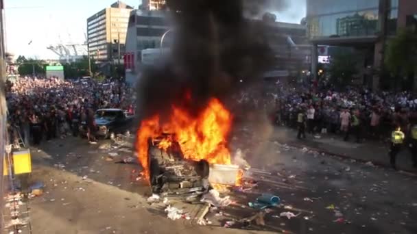 何千人もの人々と暴動の間に車の火災で荒れ狂う激しい炎 — ストック動画