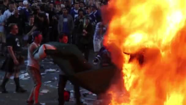 暴動中に重い敷物を引いて火の中に投げ込む男たちの小さなグループ — ストック動画