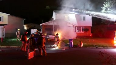 Diğerleri Montreal 'deki evde dolaşırken itfaiyeci araba yangınını söndürüyor.