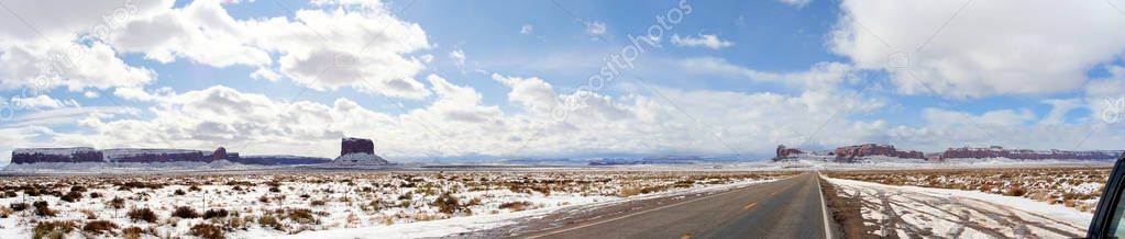 Cloudy skies over the desert on US Route 163 looking south to Monument Valley after a snowfall, Utah, USA