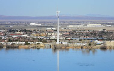 Wind turbine reflected on a surface of the Lake Palmdale, Mojave Desert, California clipart