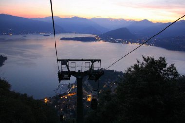 Laveno 'da Lago Maggiore' un doğu kıyısındaki teleferik asansörü, alacakaranlıktaki göl manzarası, Laveno-Mombello, İtalya - 6 Ağustos 2015