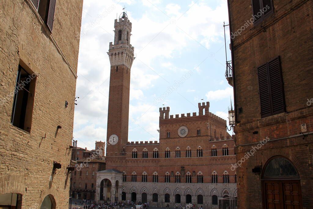 The Mangia Tower, Torre del Mangia, and the adjacent the Public Palace, Palazzo Pubblico, the city hall, Siena, Italy - July 27, 2015