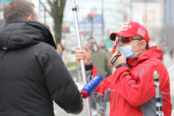 Rus televizyon kanalı Rossija, USNS COMFORT 'un New York, Manhattan West Side, New York, New York, ABD' ye gelişi üzerine 30 Mart 2020 'de rıhtım tarafındaki destekçiyle röportaj yapıyor.