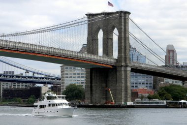 Brooklyn Köprüsü, New York, New York, ABD 'nin arka planında 17 Eylül 2010' da East River 'da beyaz motorlu yat yolda.